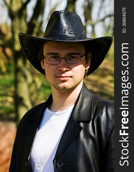 Young Attractive Man In A Black Leather Coat And Hat