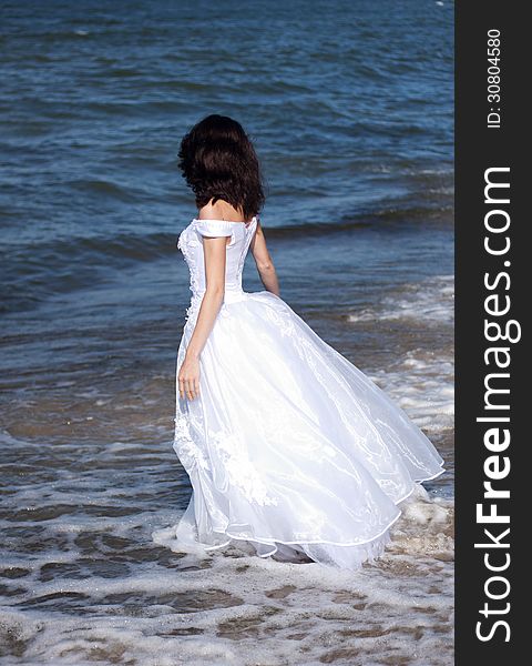 Young girl in white dress on the seashore