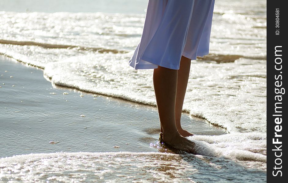 Girl's legs on the beach on sunny summer day