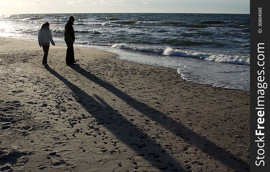 Two silhouettes of people on the beach