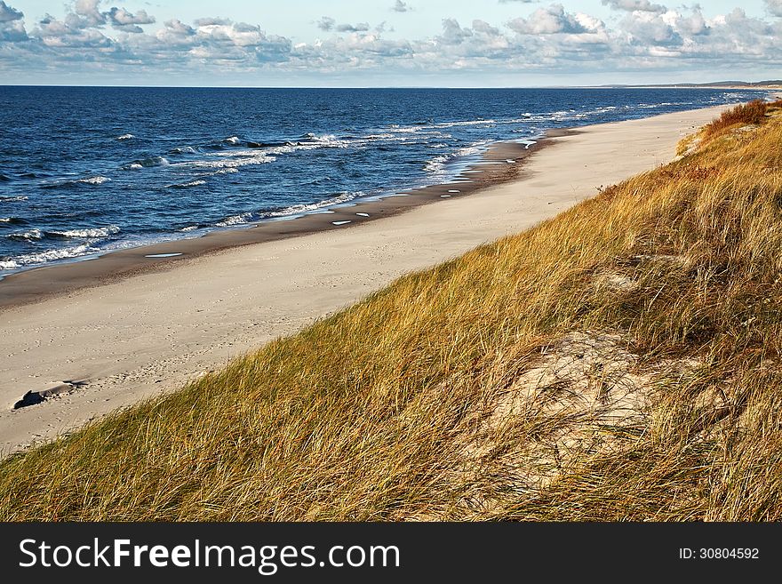 Sandy seashore with cloudy sky