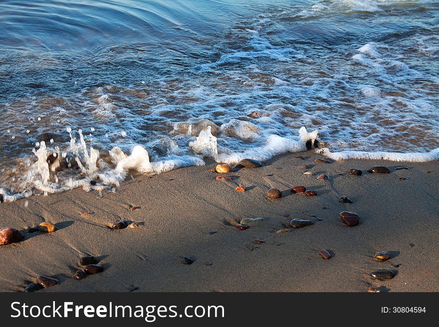 Sandy seashore with stones closeup