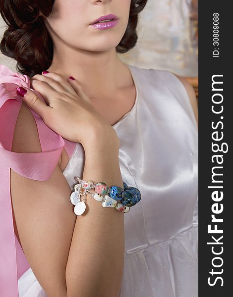Young attractive woman wearing a bracelet and a satin bridal designer gown. Young attractive woman wearing a bracelet and a satin bridal designer gown