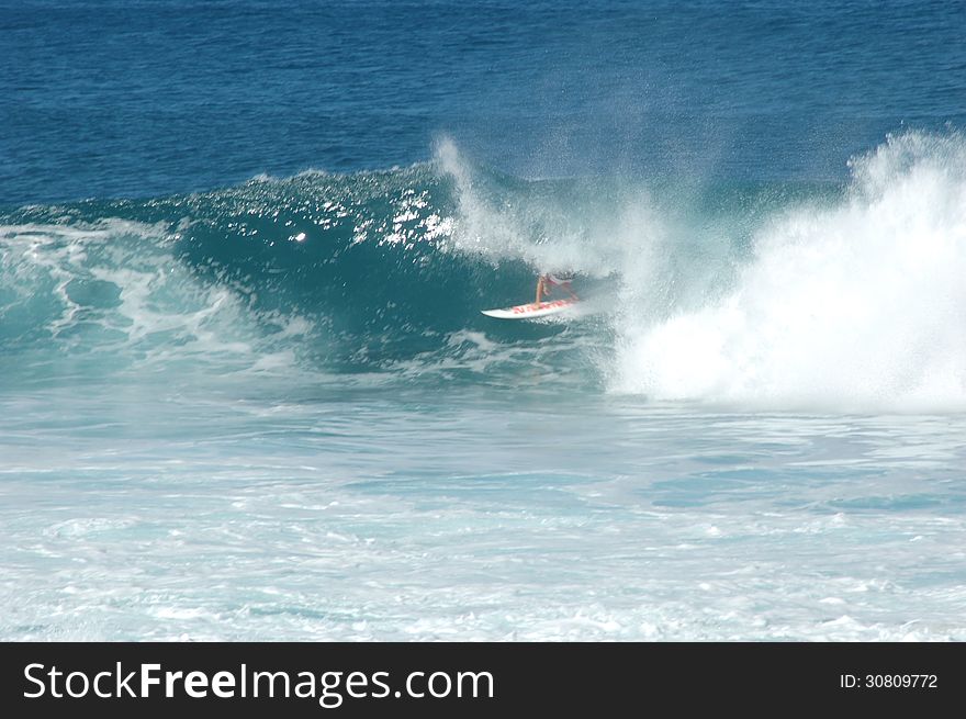 A surfer perched perfectly in the tube of a wave. Back Door. Ehukai Beach. North Shore. Hawaii.