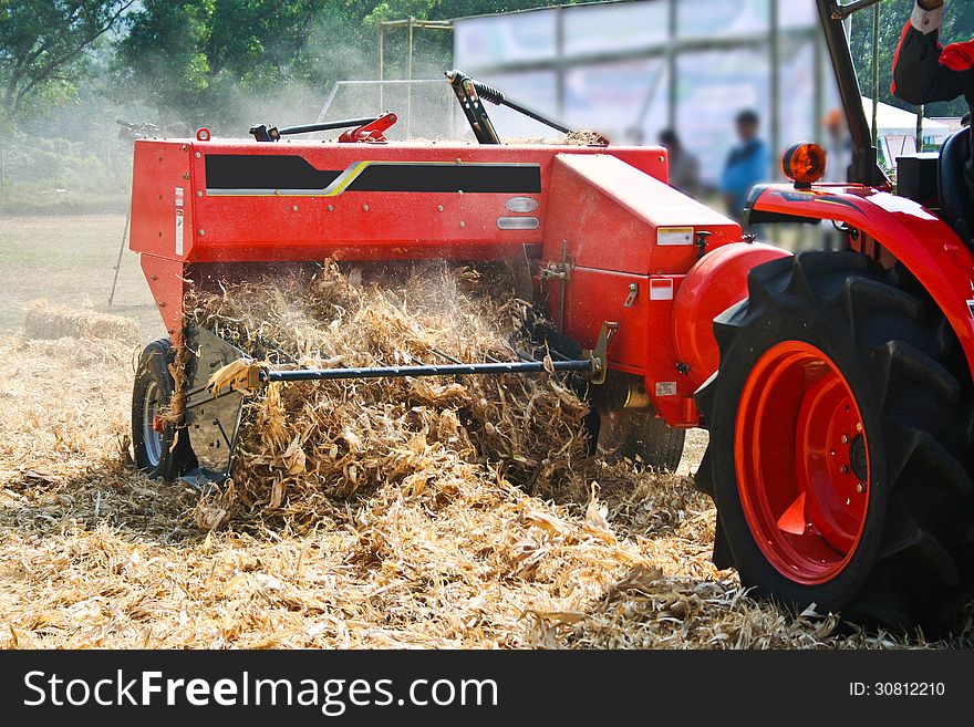 Corn cob briquette and tractor orange color on field