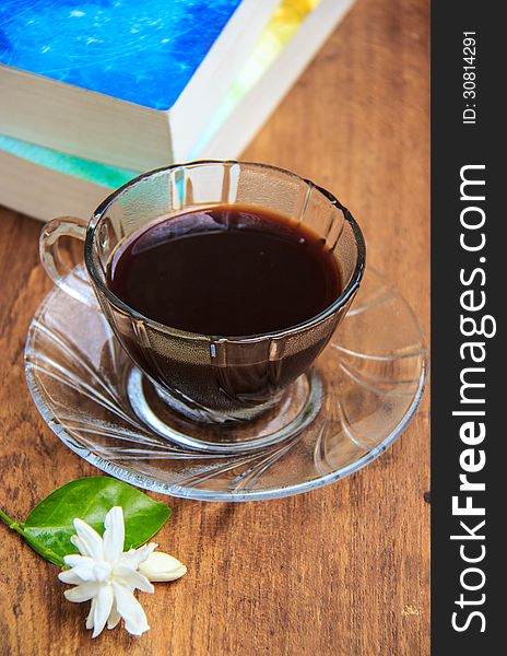 Black coffee on wooden table with old books and Jasmine flower. Black coffee on wooden table with old books and Jasmine flower