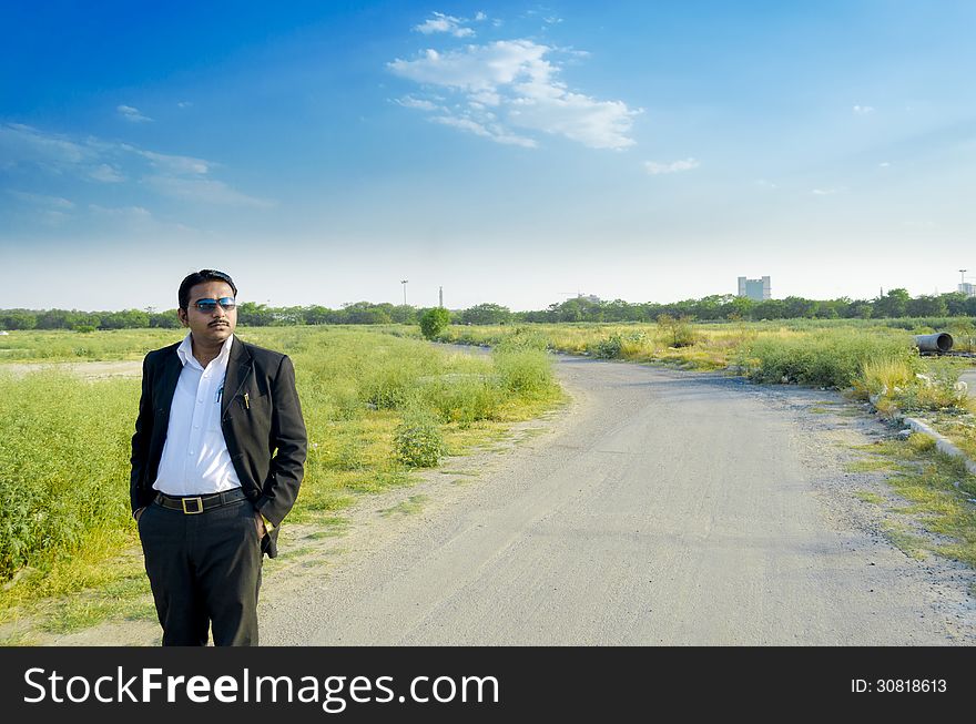 Confident business man standing on road landscape. Confident business man standing on road landscape
