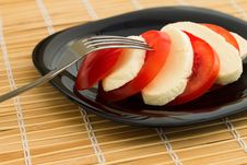 Tomato And Mozzarella On Black Dish At Bamboo Royalty Free Stock Photos