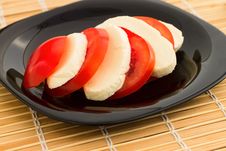Tomato And Mozzarella On Black Dish At Bamboo Royalty Free Stock Photo
