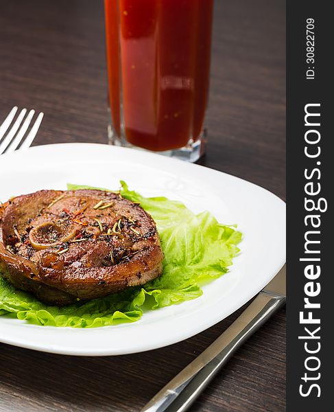 Glass of tomato juice with grilled steak with salad on white plate. Glass of tomato juice with grilled steak with salad on white plate