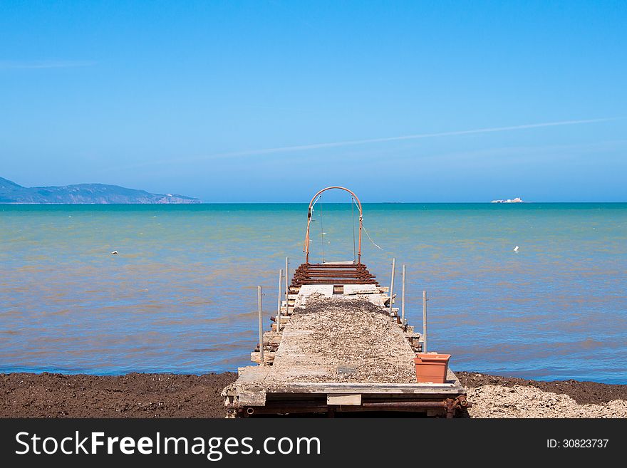 Old pier in the beach out of season, Mediterranean sea. Old pier in the beach out of season, Mediterranean sea