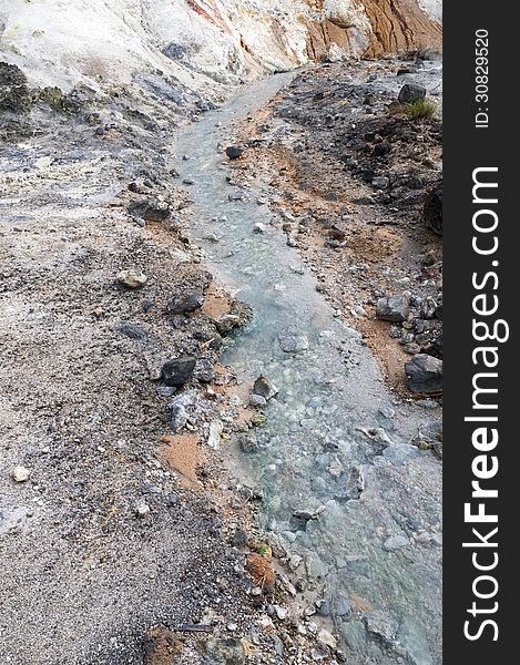 Hot springs stream flows between volcanic rocks