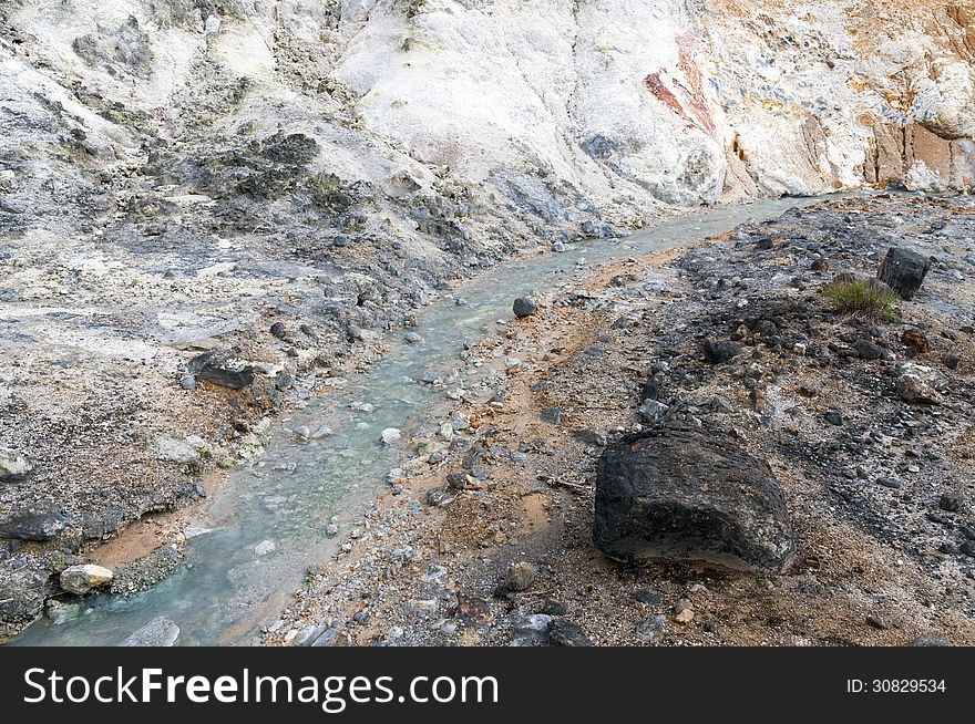 Hot springs stream flows between volcanic rocks