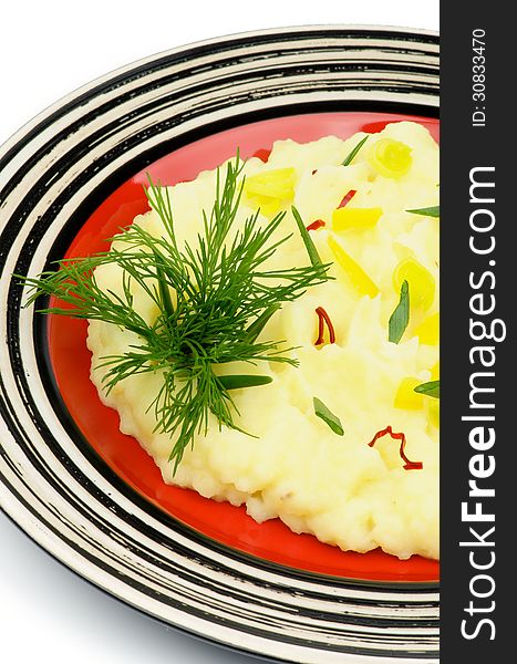 Mashed Potato Garnished with Dill, Spring Onion, Leek and Chili on Red Plate closeup