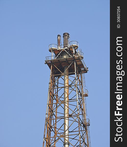 Top of distillation tower in blue sky and sunlight