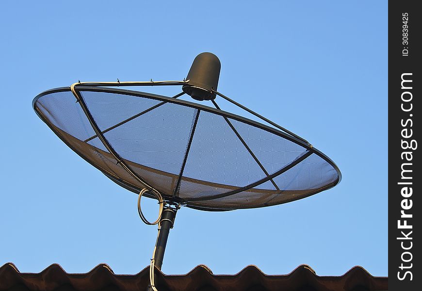 Black satellite dish on roof in sunlight. Black satellite dish on roof in sunlight