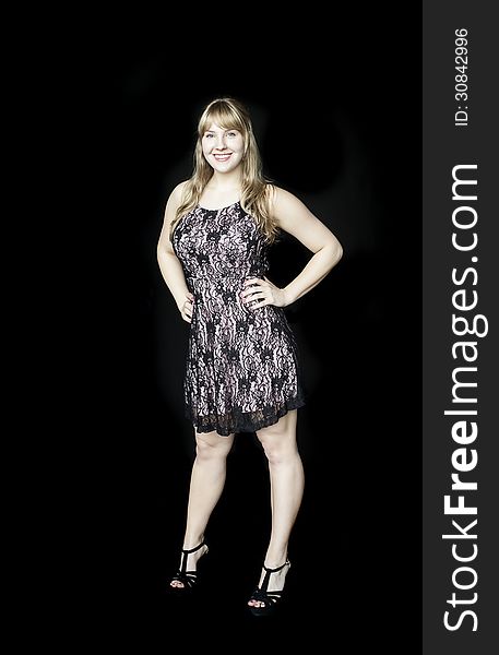 Portrait of a beautiful blond woman in a pretty dress on a black background. Portrait of a beautiful blond woman in a pretty dress on a black background.