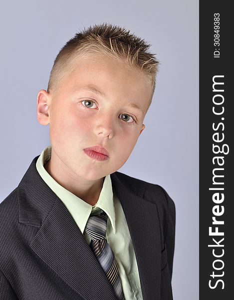Headshot of handsome young serious business boy in suit on gray background. Headshot of handsome young serious business boy in suit on gray background