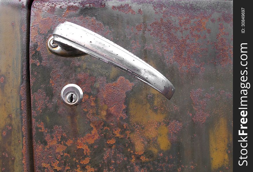 Close-up of a door handle on the old and rusty door of a pick-up truck. Suitable for background with room for copy or text. Close-up of a door handle on the old and rusty door of a pick-up truck. Suitable for background with room for copy or text.