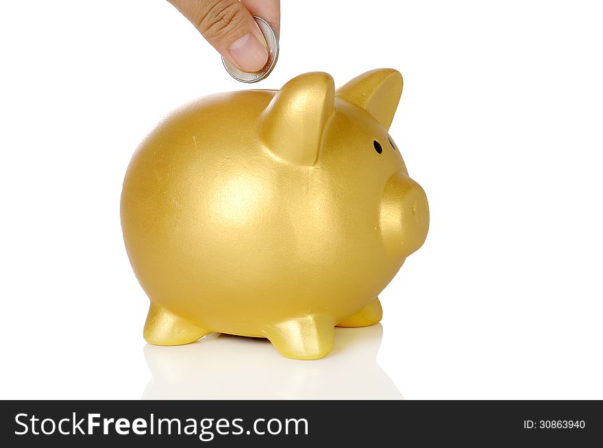 Human hand put coin into piggy bank isolated over white background