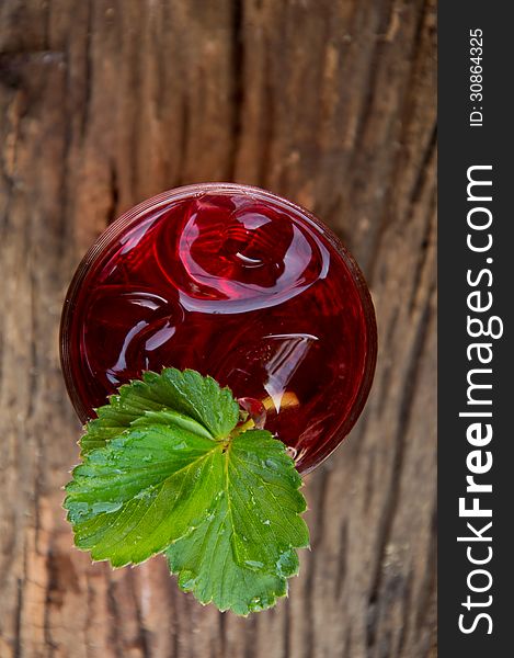 Strawberry juice and leaves on wood. Strawberry juice and leaves on wood