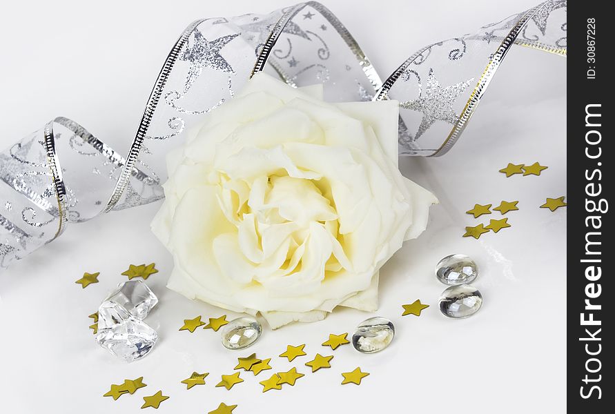 Decorative composition with a white rose and gold stars