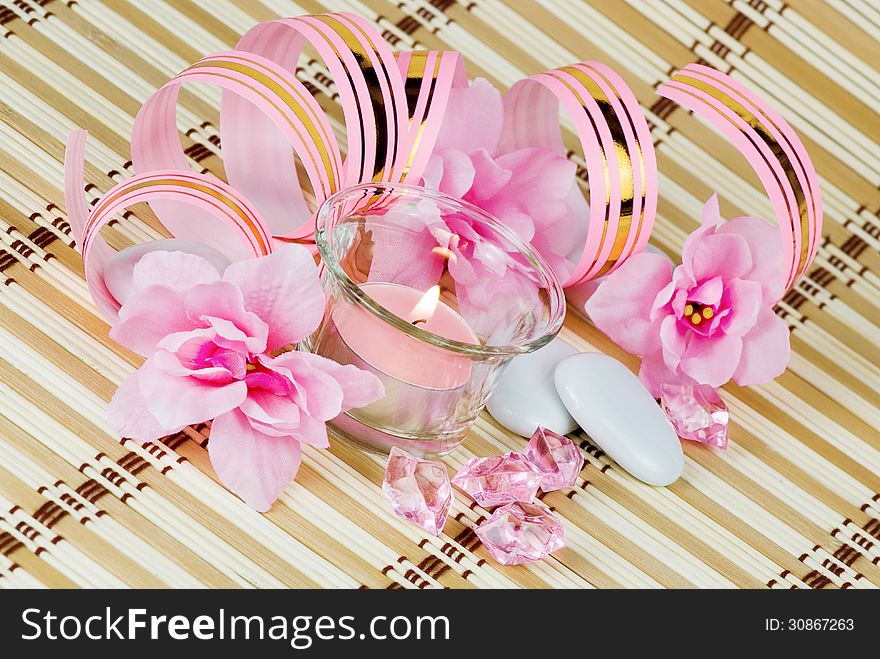 Pink flowers, burning candle and colored pieces of ice. Pink flowers, burning candle and colored pieces of ice