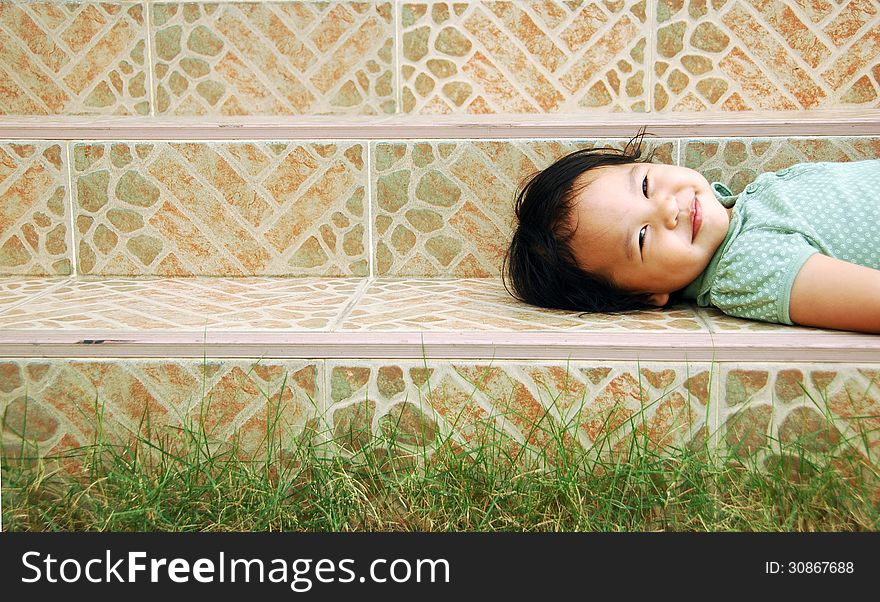 Laying smile kid on a stairway