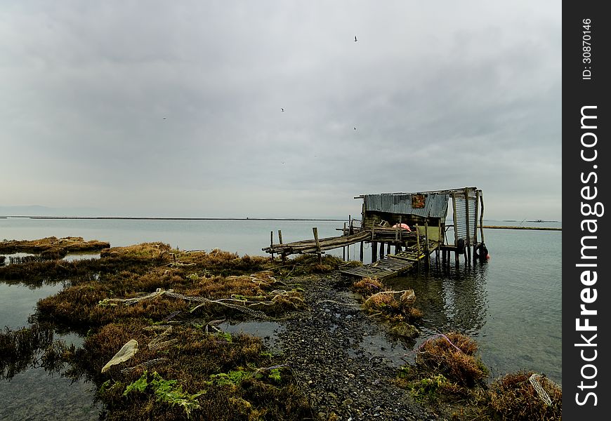 Fisherma's hut with reflection in still waters, Greece Axios outfall. Fisherma's hut with reflection in still waters, Greece Axios outfall