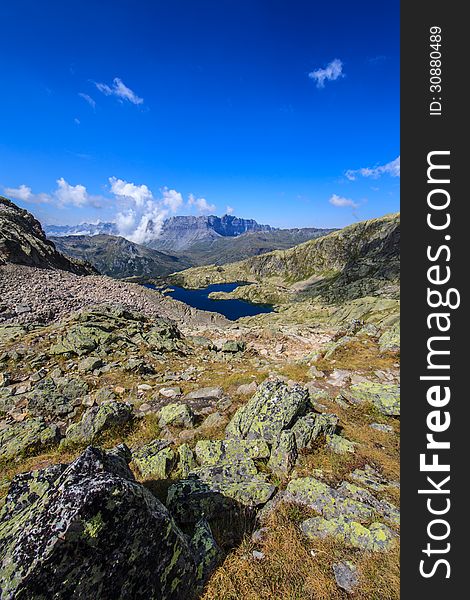 Mountain  scenery in the French Alps in summer, with rocky cliffs and cloudy sky