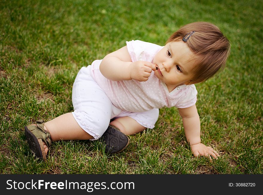 Portrait of beautiful baby girl on the lawn