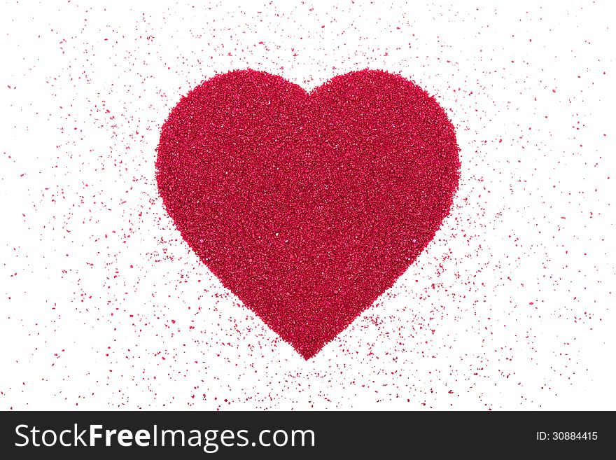 Heart made of decorative red sand is on a white background. Heart made of decorative red sand is on a white background.