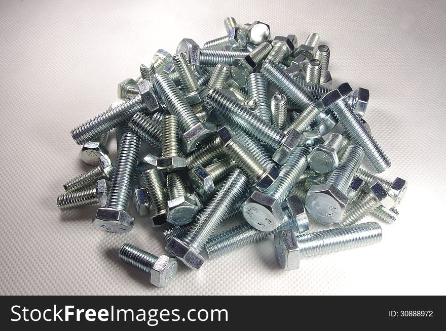 The photograph shows metal screws on a white background. The photograph shows metal screws on a white background.