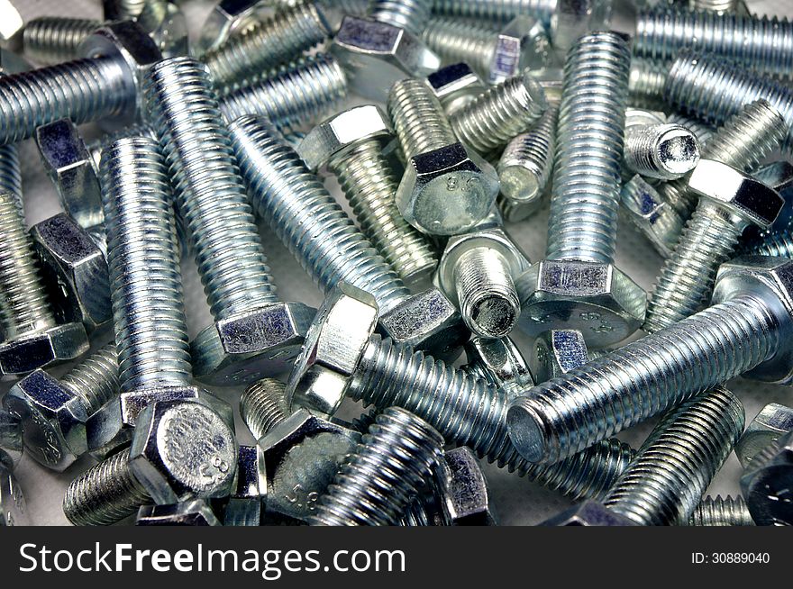 The photograph shows metal screws scattered on the ground. The photograph shows metal screws scattered on the ground.