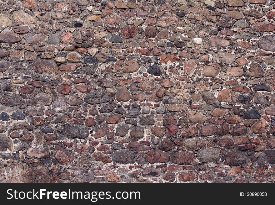 The photograph shows a fragment of an old, old wall made ​​of stones. The photograph shows a fragment of an old, old wall made ​​of stones.