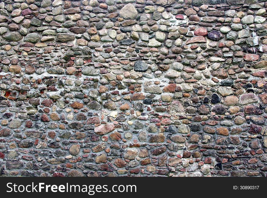 The photograph shows a fragment of an old, old wall made â€‹â€‹of stones. The photograph shows a fragment of an old, old wall made â€‹â€‹of stones.