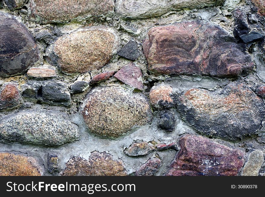 The photograph shows a fragment of an old, old wall made ​​of stones. The photograph shows a fragment of an old, old wall made ​​of stones.