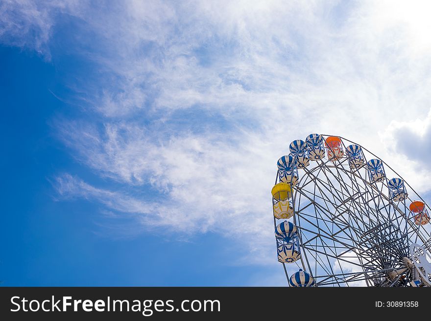 Part of ferris wheel with clear blue sky