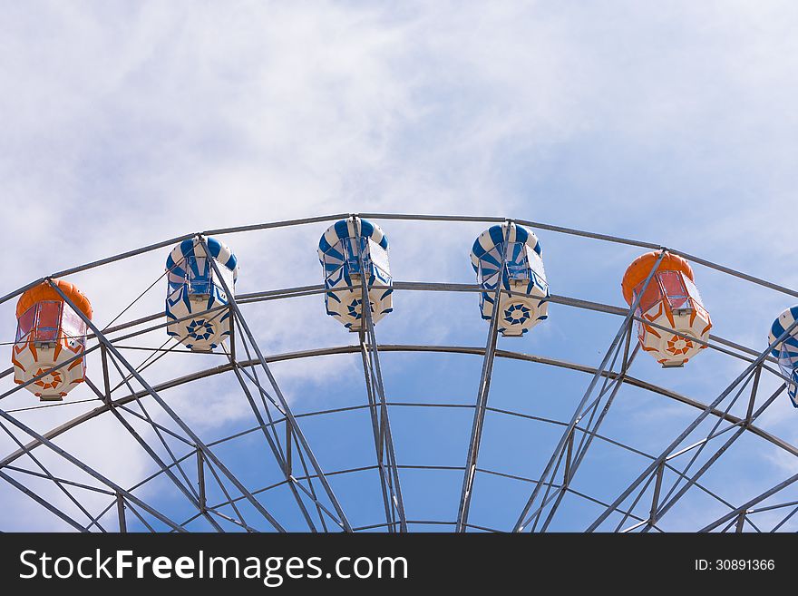 Part of ferris wheel with clear blue sky. Part of ferris wheel with clear blue sky