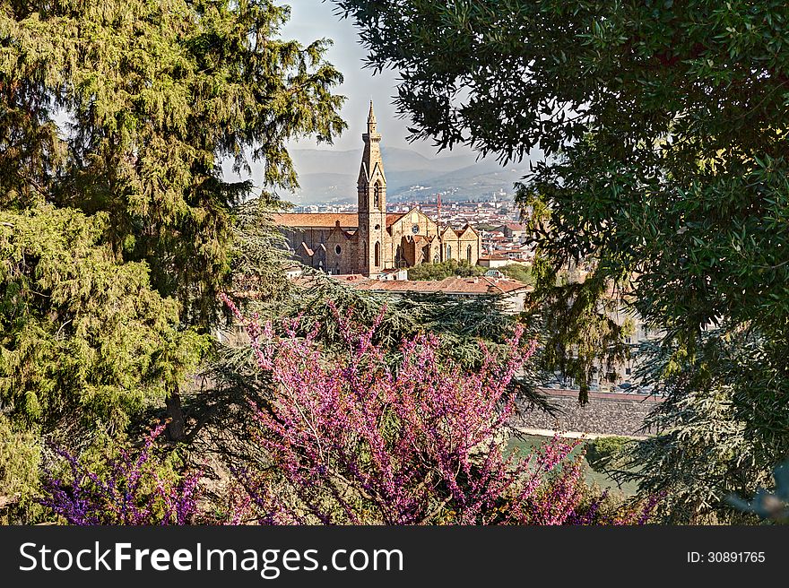 View of the famous cathedral Basilica di Santa Croce in Florence, Italy, at spring, framed with green leaves and flowers. View of the famous cathedral Basilica di Santa Croce in Florence, Italy, at spring, framed with green leaves and flowers