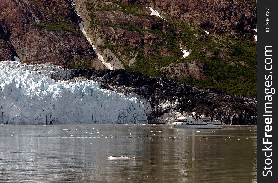 Glacier flowing into ocean in Alaska with a ship in the water. Glacier flowing into ocean in Alaska with a ship in the water