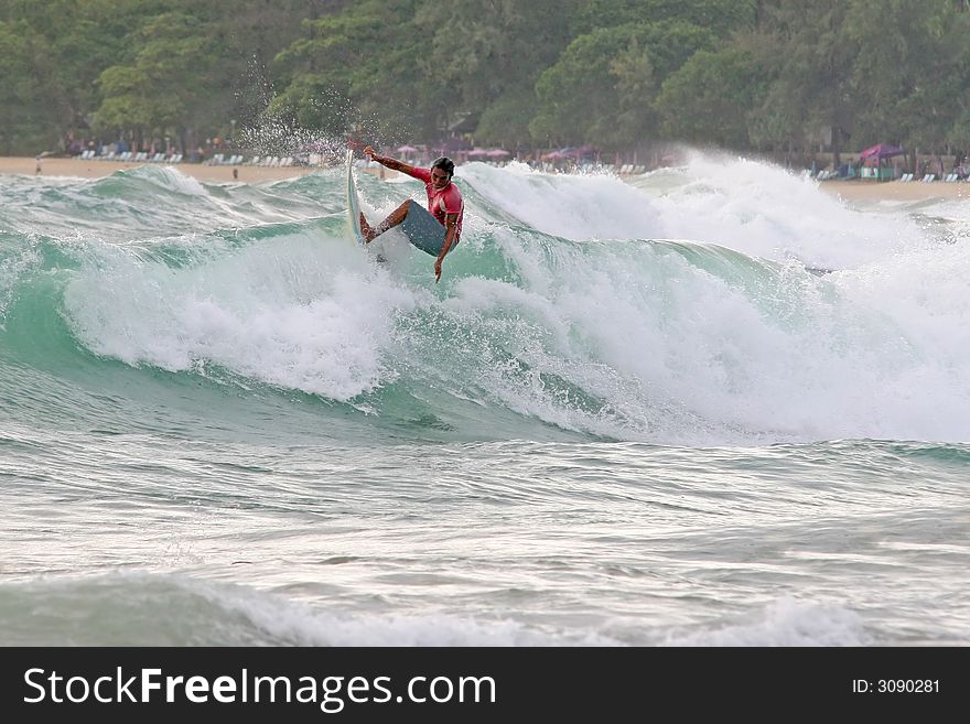 A local surfer hits the lip of a wave on a beach in Phuket, Thailand. A local surfer hits the lip of a wave on a beach in Phuket, Thailand