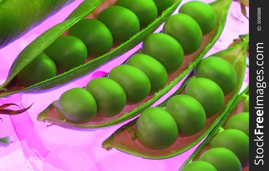 Green peas on a pink background