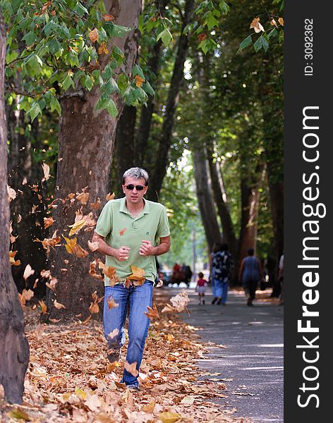 Man running in a forest leaves falling around