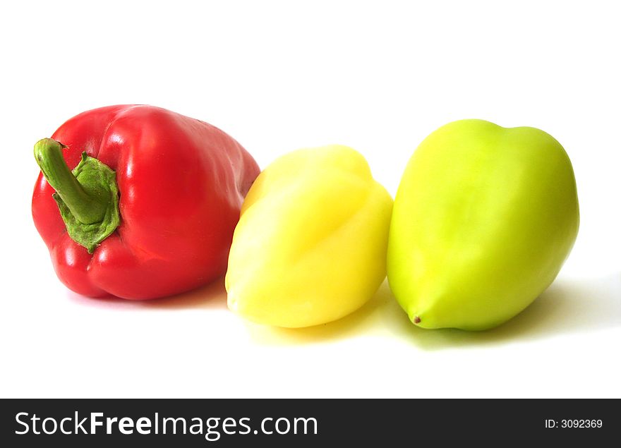 Red, yellow and green peppers over white background