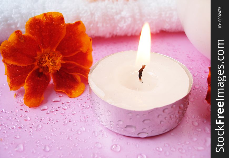Cosmetic moisturizing cream and candle with flowers