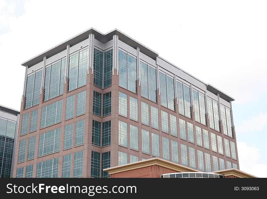 A modern brick and glass building with clouds. A modern brick and glass building with clouds