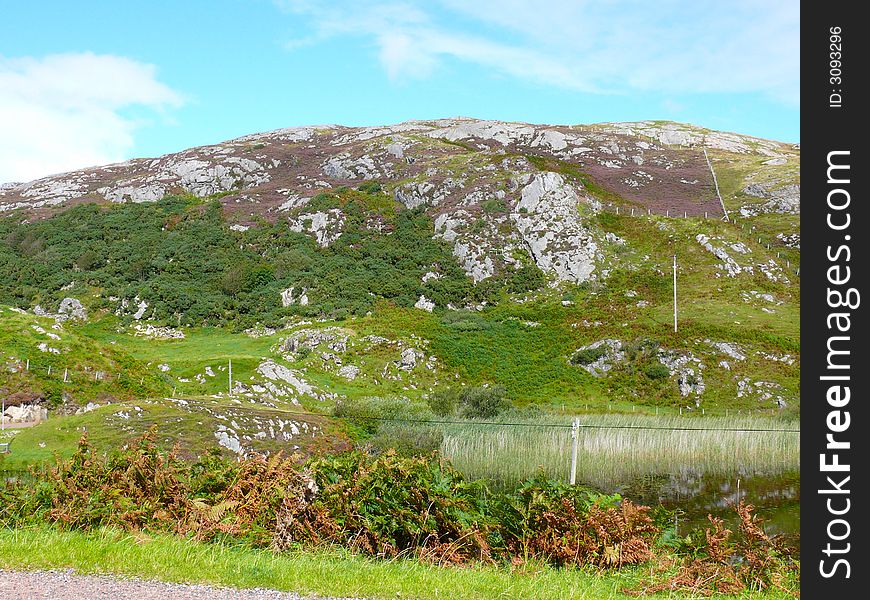 The rocky skyline of Tarbert in scotland with the sunken power poles by the little loch in view. The rocky skyline of Tarbert in scotland with the sunken power poles by the little loch in view.