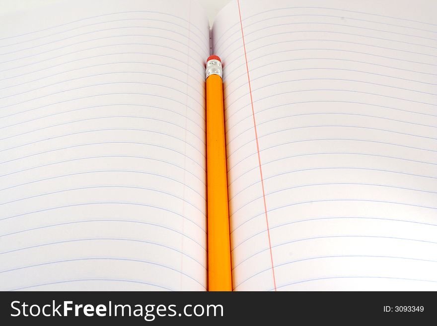 A Yellow pencil on a blacnk notepad. A Yellow pencil on a blacnk notepad