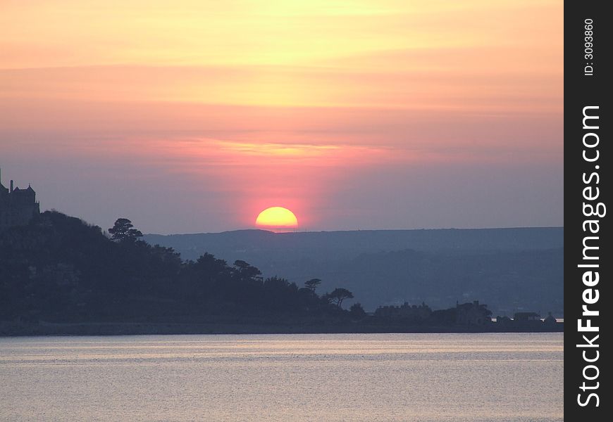 Sunset over sea in Cornwall by St. Michaels Mount